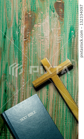 Blue book of the Holy bible and a Christian cross on a wooden table. Symbol of faith in God. Concept of Spirituality, Christianity, religion, faith, Jesus, or belief 132334097