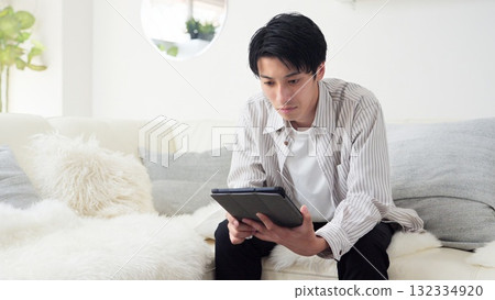 亞洲男子表情嚴肅地看新聞 亞洲男子表情嚴肅地看新聞 132334920