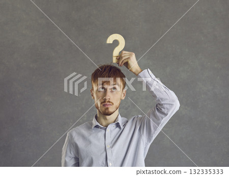 Puzzled young beginner businessman is looking for answers about the development of his business. Puzzled young beginner businessman is looking for answers about the development of his business. 132335333