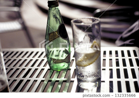 餐廳庭院裡的一張桌子,一杯碳酸水和檸檬 餐廳庭院裡的一張桌子,一杯碳酸水和檸檬 132335666