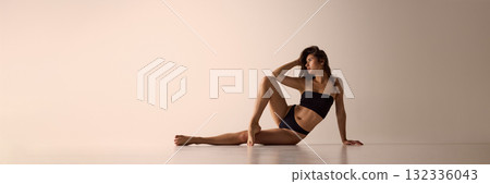 Woman in black lingerie sitting on floor with elegant pose for modern underwear ads. Banner 132336043