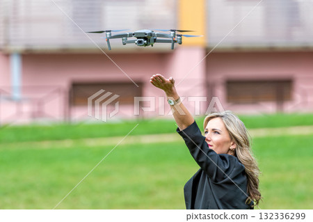 drone landing on hands of young blonde woman, modern technology concept 132336299