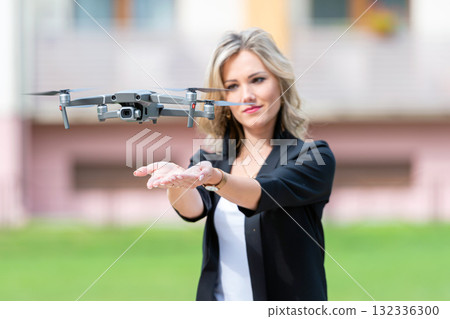 drone takes off from hands of young blonde woman, modern technology concept 132336300