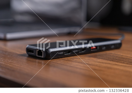 Black USB-C hub offering diverse expansion ports like HDMI and Ethernet, optimizing laptop connectivity and modern workflow for digital professionals 132336428