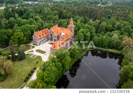 Cesvaine medieval castle in Latvia from above. Building of stones with a brown tiled roof. Cesvaine medieval castle in Latvia from above. Building of stones with a brown tiled roof. 132336556