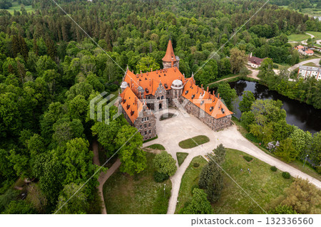 Cesvaine medieval castle in Latvia from above. Building of stones with a brown tiled roof. Cesvaine medieval castle in Latvia from above. Building of stones with a brown tiled roof. 132336560