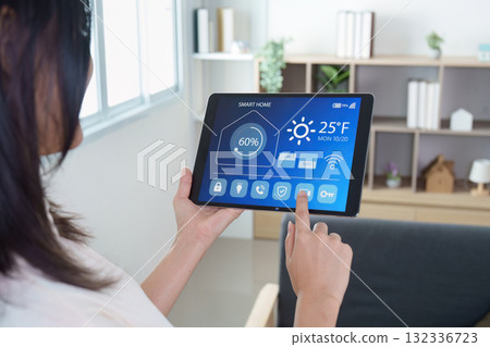 Smart Home. Woman controlling smart home system on tablet. 132336723