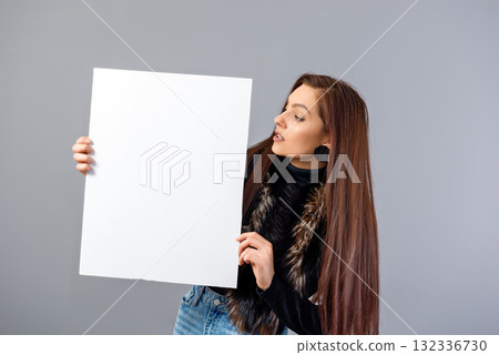 smiling young teenager woman showing blank signboard with copy space, isolated on gray smiling young teenager woman showing blank signboard with copy space, isolated on gray 132336730