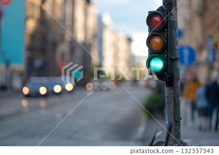 view of city traffic with traffic lights, in the foreground a semaphore with a green light, closeup view of city traffic with traffic lights, in the foreground a semaphore with a green light, closeup 132337343
