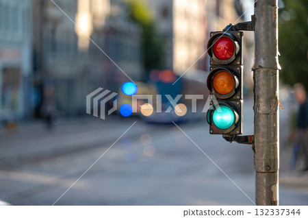 view of city traffic with traffic lights, in the foreground a semaphore with a green light, closeup view of city traffic with traffic lights, in the foreground a semaphore with a green light, closeup 132337344