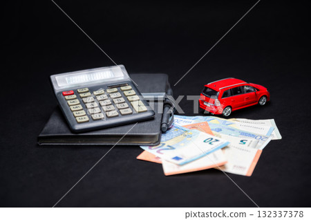 euro banknotes, calculator, notebook and red toy car on black background, insurance and loan concept euro banknotes, calculator, notebook and red toy car on black background, insurance and loan concept 132337378