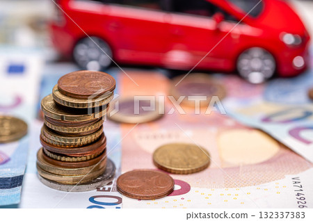 Tower with euro coins on the background of banknotes and red toy car, insurance and loan concept Tower with euro coins on the background of banknotes and red toy car, insurance and loan concept 132337383