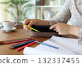 Woman hand putting pencil on case on a table 132337455