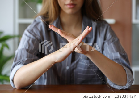 Woman hands gesturing x or stop on a table 132337457