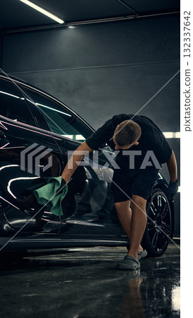 Worker wiping car side with microfiber towel during final detailing inspection Worker wiping car side with microfiber towel during final detailing inspection 132337642