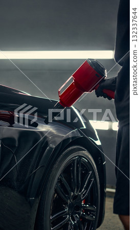 Detailer drying car fender with red air blower during precision cleaning process Detailer drying car fender with red air blower during precision cleaning process 132337644