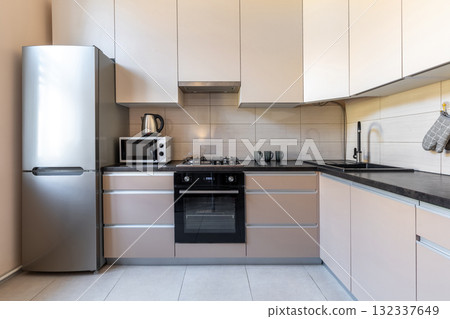 Modern Minimalist Kitchen with Beige Cabinets and Appliances 132337649