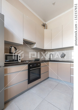 Modern Beige Kitchen with Dining Space and Black Countertop Modern Beige Kitchen with Dining Space and Black Countertop 132337651