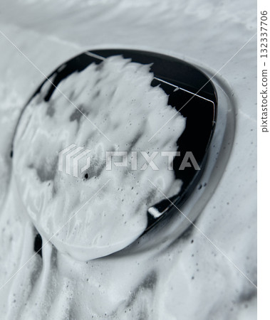 Close-up of car logo covered in foam during washing process Close-up of car logo covered in foam during washing process 132337706
