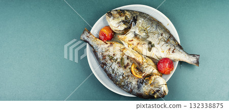 Oven-roasted fish served with plums. 132338875