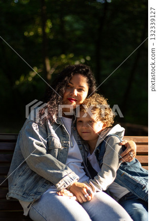 Caucasian millennial mother having rest in public park with her son in casual jeans clothes. Parenting topics. Happy family concept. 132339127
