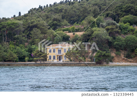 Visiting Prince Islands showcases a charming waterfront house surrounded by greenery on a tranquil day near the coast 132339445