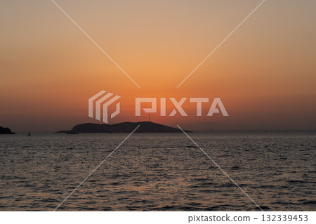 Sunset over the serene waters of Prince Islands, showcasing the calming horizon and silhouettes of distant hills Sunset over the serene waters of Prince Islands, showcasing the calming horizon and silhouettes of distant hills 132339453