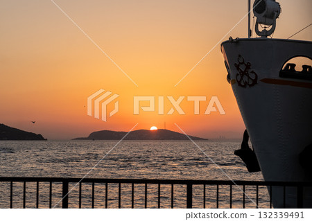 Captivating sunset over the sea with a ferry silhouette near Prince Islands offering a serene moment of tranquility in nature Captivating sunset over the sea with a ferry silhouette near Prince Islands offering a serene moment of tranquility in nature 132339491
