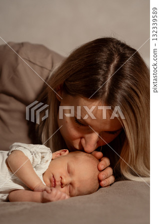 Tender moment shared between a mother and her newborn baby in a cozy indoor setting Tender moment shared between a mother and her newborn baby in a cozy indoor setting 132339589