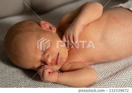 Sleepy baby resting peacefully on a soft blanket in a cozy indoor space during the day Sleepy baby resting peacefully on a soft blanket in a cozy indoor space during the day 132339672