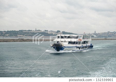 Nautical journey across the Bosphorus with a ferry navigating the waters under overcast skies Nautical journey across the Bosphorus with a ferry navigating the waters under overcast skies 132339901