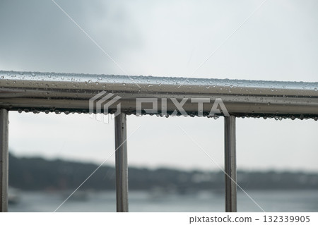 Rain drops on a metal railing by the Bosphorus during a cloudy day reflecting urban life in Istanbul Rain drops on a metal railing by the Bosphorus during a cloudy day reflecting urban life in Istanbul 132339905