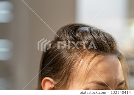 Color changing process of hair observed during a salon appointment in a modern studio setting Color changing process of hair observed during a salon appointment in a modern studio setting 132340414