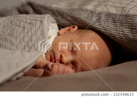 Peaceful moment between mother and sleeping baby in cozy bedding 132340615