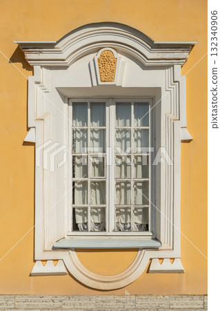 Historic window design on a vibrant yellow building at Peterhof demonstrating rich architectural detail and elegance Historic window design on a vibrant yellow building at Peterhof demonstrating rich architectural detail and elegance 132340906
