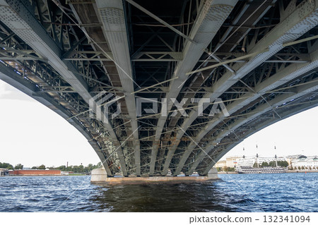 View of the intricate understructure of a bridge in Saint Petersburg, showcasing its engineering design over the water View of the intricate understructure of a bridge in Saint Petersburg, showcasing its engineering design over the water 132341094