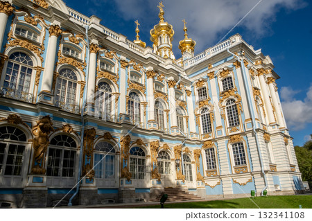 Explore the intricate architecture of Catherine Palace with its stunning golden domes and ornate decorations against a clear blue sky Explore the intricate architecture of Catherine Palace with its stunning golden domes and ornate decorations against a clear blue sky 132341108