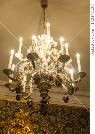Chandelier adorned with floral details illuminating the interior of Peterhof Palace in Russia Chandelier adorned with floral details illuminating the interior of Peterhof Palace in Russia 132341126
