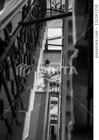 Moody black and white stairwell with woman Moody black and white stairwell with woman 132341158