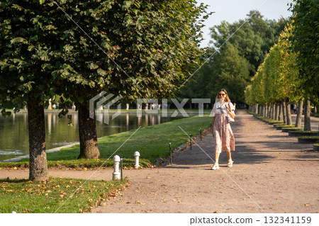 Strolling through the gardens of Peterhof during a sunny afternoon in summer Strolling through the gardens of Peterhof during a sunny afternoon in summer 132341159
