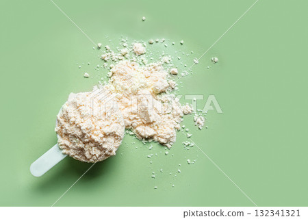 Scoop of whey protein powder on green 132341321