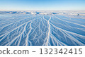 Frozen Lake Surface with Ice Patterns under a Clear Blue Sky 132342415