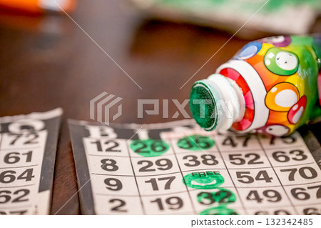 Bingo cards and markers display fun and excitement during a lively game night with friends 132342485