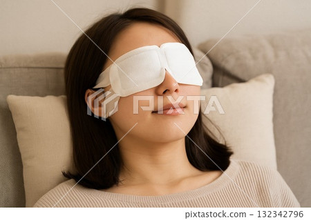 Woman relaxing with a hot eye mask 132342796
