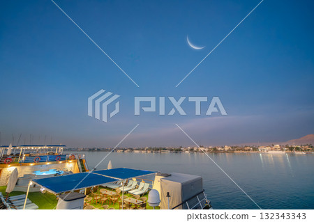 Crescent moon over Luxor West Bank from Nile River cruise ship at dawn. Crescent moon over Luxor West Bank from Nile River cruise ship at dawn. 132343343
