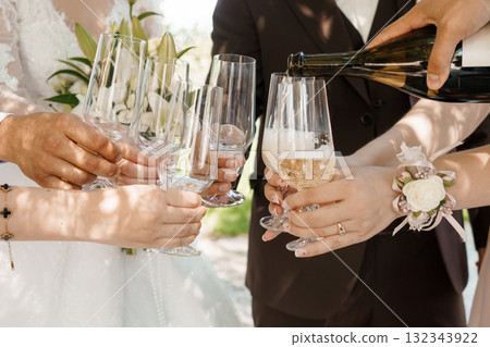 Elegant Wedding Champagne Toast: Celebrating Couple with Sparkling Wine Glasses, Outdoor Reception, Warm Sunlight, Ivory and Brown Tones, Joyful Moment. Elegant Wedding Champagne Toast: Celebrating Couple with Sparkling Wine Glasses, Outdoor Reception, Warm Sunlight, Ivory and Brown Tones, Joyful Moment. 132343922