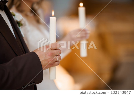 Wedding Unity Candle Ceremony: Groom and Bride Lighting Candles in Church, Warm Lighting, Romantic Atmosphere, Traditional Celebration. Wedding Unity Candle Ceremony: Groom and Bride Lighting Candles in Church, Warm Lighting, Romantic Atmosphere, Traditional Celebration. 132343947