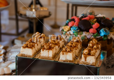Elegant Dessert Table Display with Caramel Squares, Walnut Toppings, and Colorful Chocolate Treats Luxury Pastry Selection in Golden Hues Elegant Dessert Table Display with Caramel Squares, Walnut Toppings, and Colorful Chocolate Treats Luxury Pastry Selection in Golden Hues 132343958