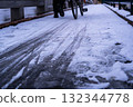 A snowy morning, frozen asphalt and a bicycle being pushed 132344778