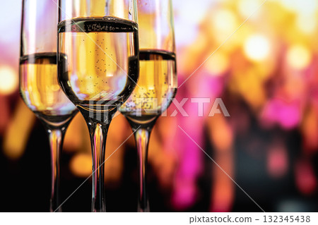 Champagne glasses amid night fireworks, Celebrating New Year with sparkling drinks and fireworks 132345438